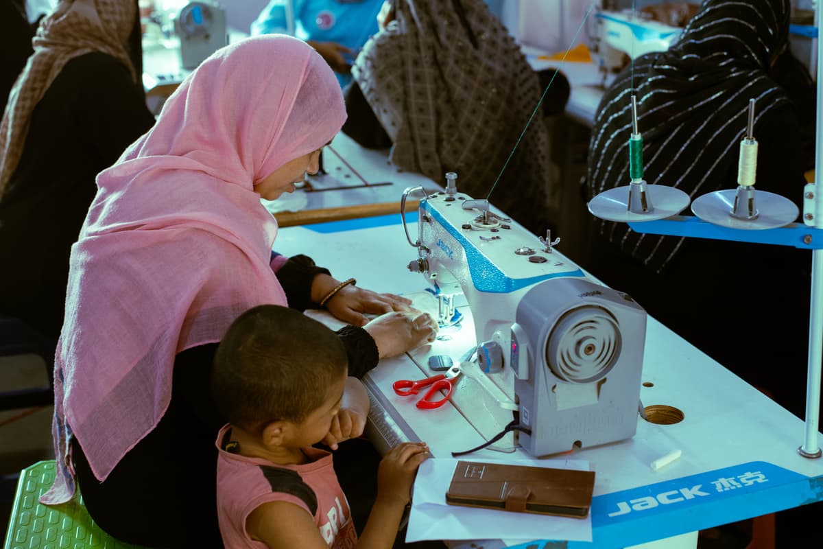 A woman building vocational skills at a sewing machine